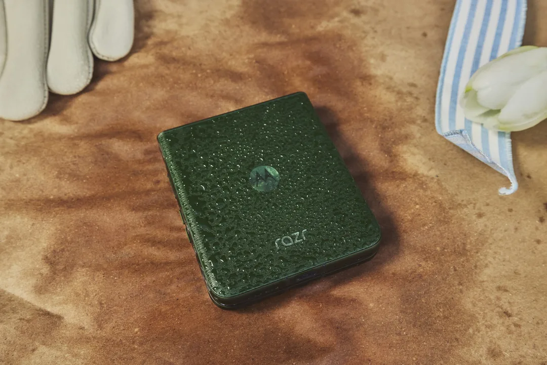 Motorola Razr 摺起後放喺桌上,機背沾上水點展示耐用設計