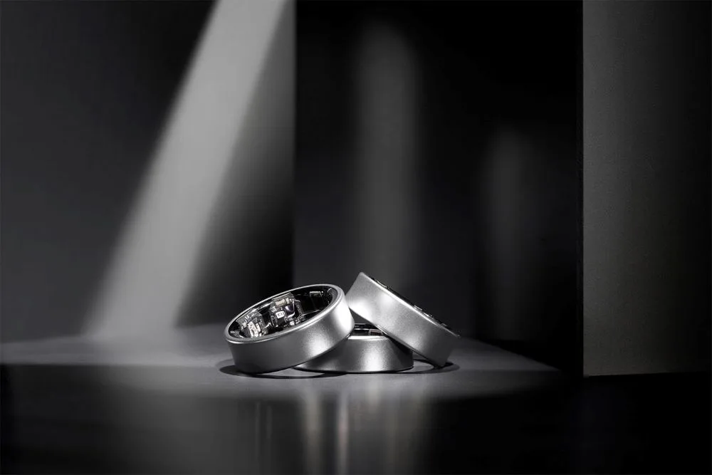 Samsung Galaxy Ring 連同充電盒展示，旁邊有手機顯示健康數據