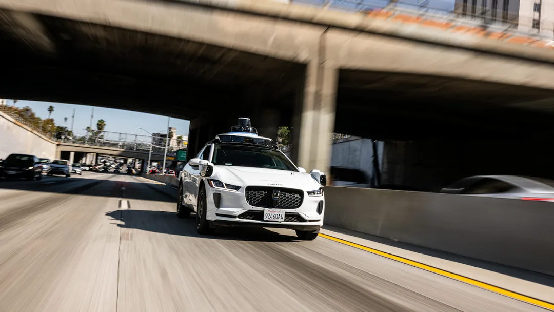 白色 Waymo Jaguar I-PACE 無人車喺 Los Angeles 高速公路行駛