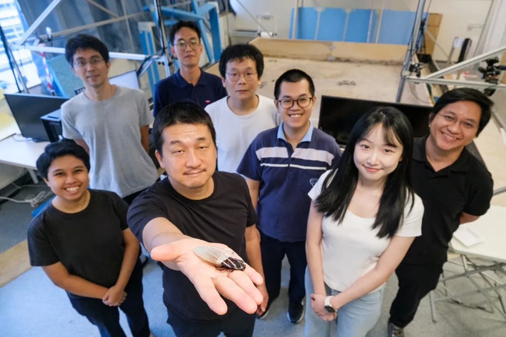 NTU 研究團隊合照,前排研究員手上托住着住潛水裝嘅賽博蟑螂