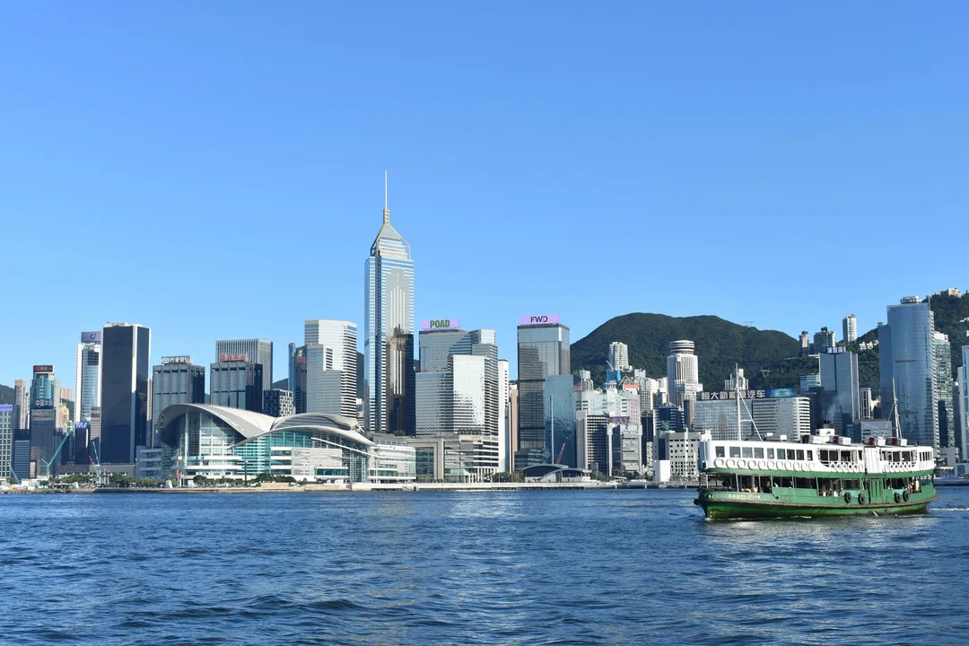 維港對岸灣仔天際線同一艘橫過海面嘅天星小輪