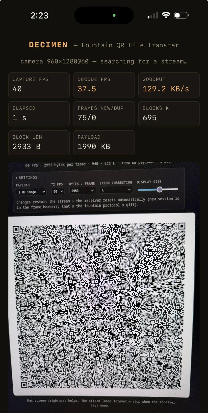 手機鏡頭對住另一個螢幕上高速轉換嘅 QR code,接收介面顯示傳輸速度同進度