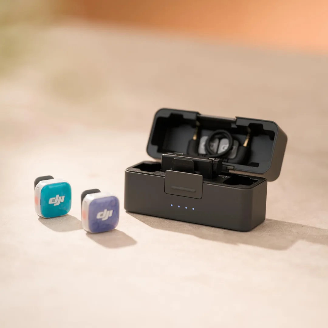 兩個彩色 DJI Mic Mini 2S 發射器放喺打開咗嘅充電盒旁邊